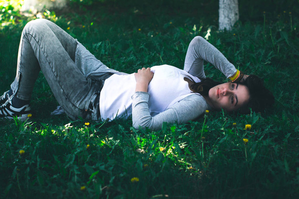Young beautiful girl lies on the grass. - Foto, imagen