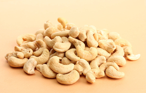 tasty cashews nuts, on beige background - Фото, зображення