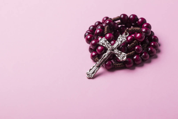 Rosary on a pink background. Christian cross. - Φωτογραφία, εικόνα