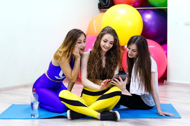 Grupo de jovens mulheres caucasianas alegres usando tablet PC em um ajuste
 - Foto, Imagem