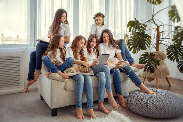 Los niños con Tablet PC se comunican en las redes sociales. Grupo de chicas adolescentes está utilizando gadgets
. - Foto, imagen