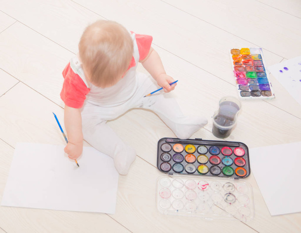 with brush and watercolor baby on the floor of the house. - Foto, immagini