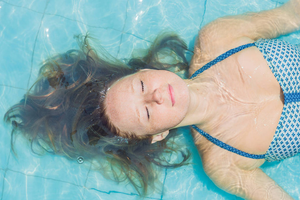 Молода жінка плаває в басейні
  - Фото, зображення