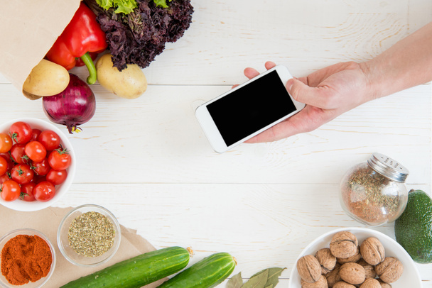 Smartphone over table with vegetables   - Photo, Image
