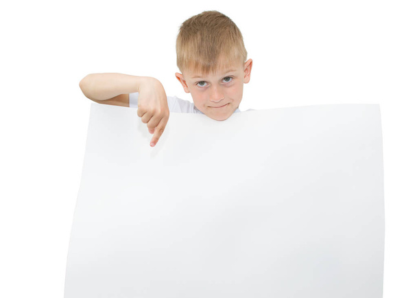 Emotional blond boy in a white shirt with a gray sheet of paper for notes on a white background - Фото, изображение