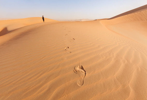 Відбитки стоп з жінкою, ходьба по піску, дюни в Liwa пустелі - Фото, зображення