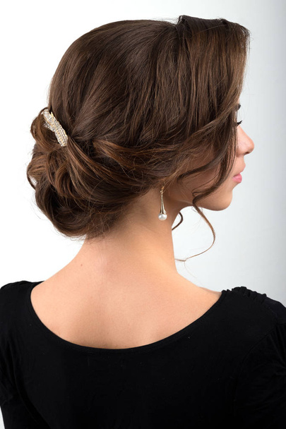 Assembled formal hairstyle dark hair decorated with a crest in the form of sheets, view profile - Фото, зображення