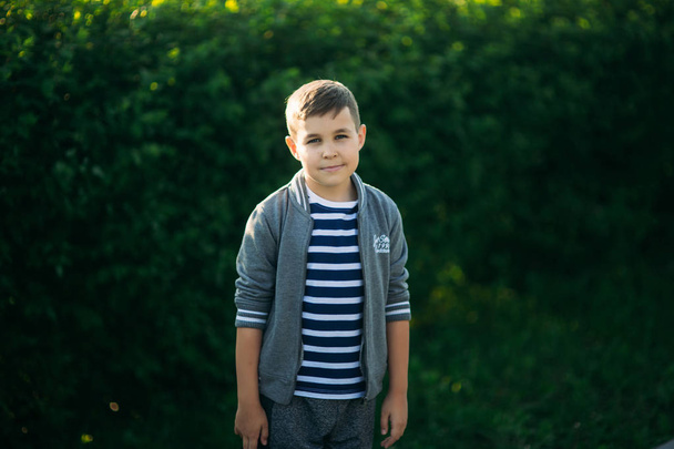 Little boy in a striped t-shirt looks through binoculars .Spring, sunny weather. - Фото, зображення