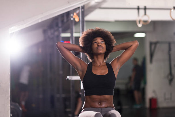 black woman doing sit ups at the gym - 写真・画像