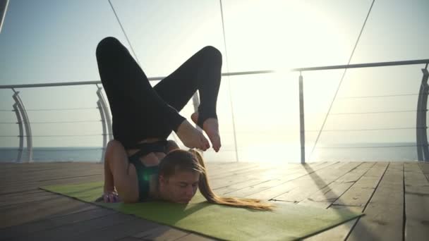 Mujer joven haciendo un duro ejercicio en la alfombra verde cerca de la playa
 - Metraje, vídeo