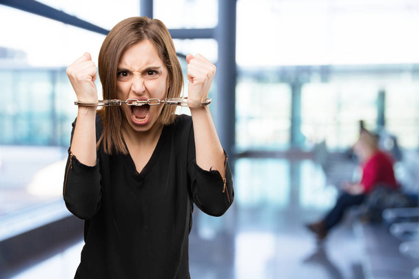 angry pretty woman with handcuffs - Фото, зображення