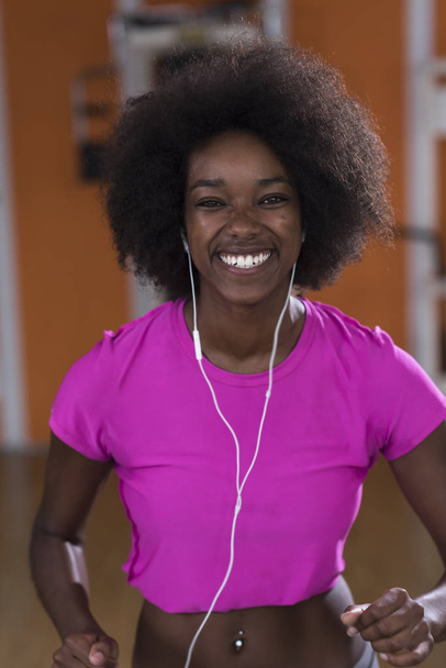 afro american woman running on a treadmill - Foto, imagen