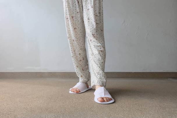 Closeup Photo of From Woman Feet Wearing White Slippers Indoor On The Ground  - Foto, immagini