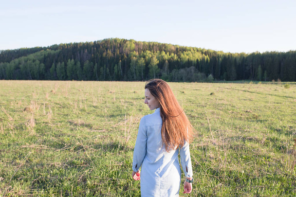 girl standing back on grass - Foto, imagen