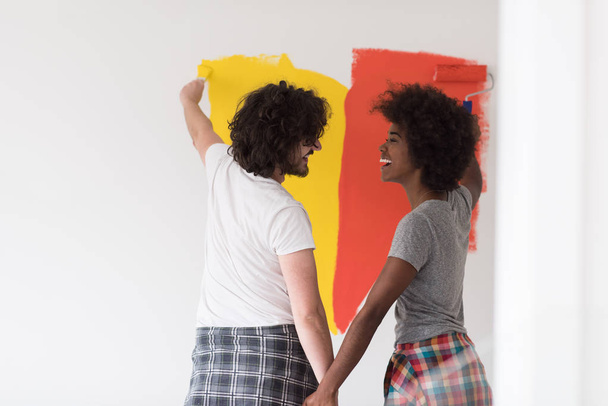 multiethnic couple painting interior wall - Foto, Imagen