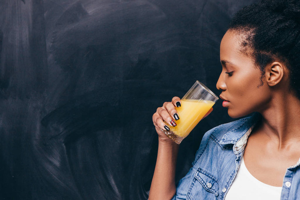 African woman drink orange juice. Healthy life. - Фото, изображение
