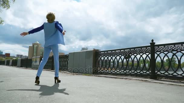 happy excited businesswoman jumping into blue sky celebrating arms outstretched slow motion - Materiał filmowy, wideo