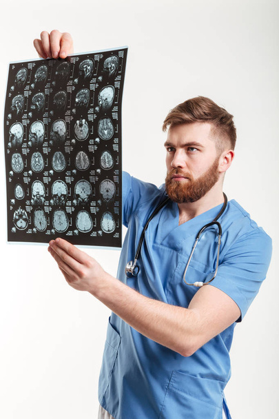 Portrait of a young medical doctor analyzing a CT scan - Фото, зображення