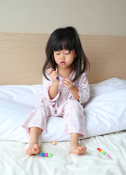 Little child girl play and learn magic color on the bed at the morning. - Foto, Imagem