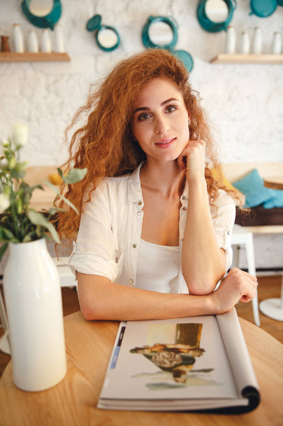Attractive beautiful redhead young lady sitting in cafe - Photo, Image
