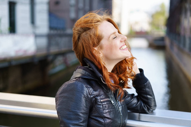 Happy carefree young woman relaxing on a bridge - Фото, зображення