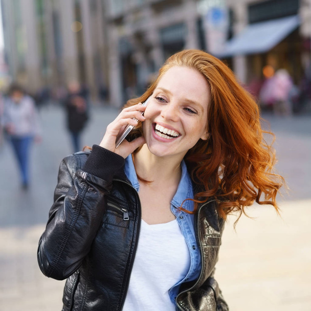 Happy woman laughing as she listens to a call - Fotoğraf, Görsel