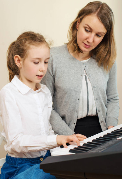 Öğretim piyano çalmak için küçük kız kadın. - Fotoğraf, Görsel