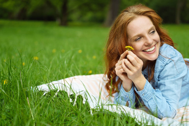 Happy relaxed young woman holding a dandelion - 写真・画像
