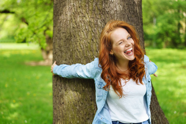 Precocious young redhead woman winking - Foto, afbeelding