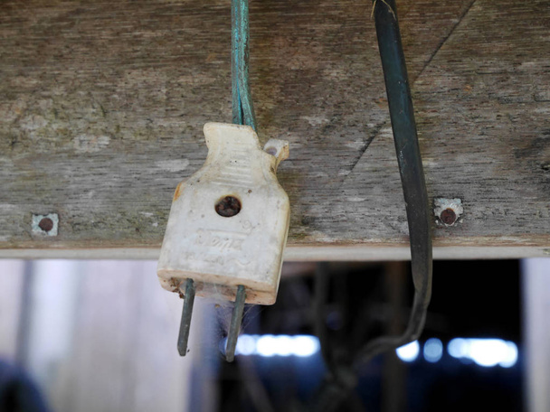 Старий зламаний електричний вилка висить в будинку
 - Фото, зображення