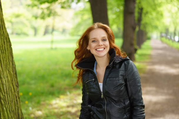 Smiling happy young woman walking in a park - Фото, зображення