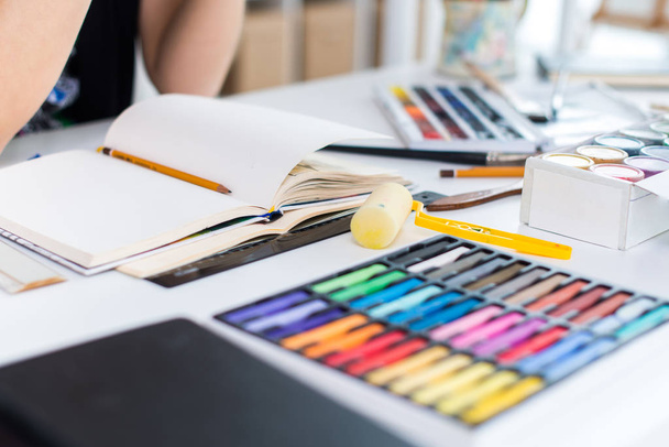 Közelkép, szög, kilátás a tervezet vázlatfüzet segítségével ceruza rajz női festő. Előadó-művészeti stúdió ceruzák készlettel vonalvezetés. - Fotó, kép