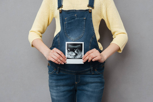 Cropped image of pregnant woman holding ultrasound scan - Foto, Imagem