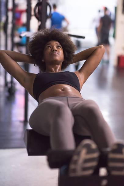 black woman doing sit ups at the gym - Foto, imagen