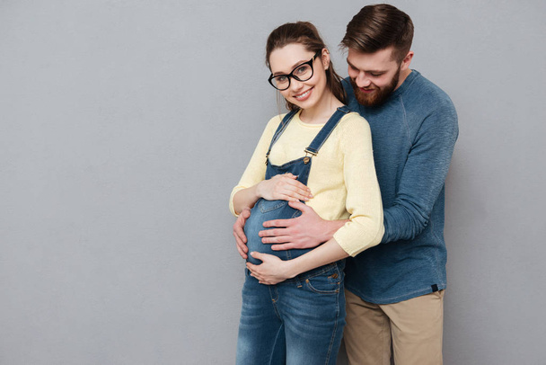Pregnant cheerful woman hugging happy man - Foto, immagini