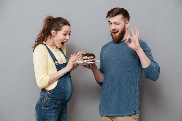 Mąż daje płyta z chocolae ciasto do żony w ciąży - Zdjęcie, obraz