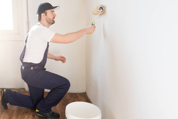 Professional painter worker is painting one wall - Photo, Image