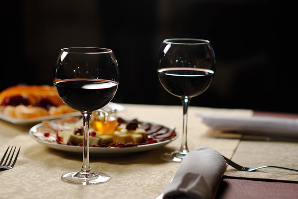 two glasses of red wine on the background of the dishes in the r - 写真・画像