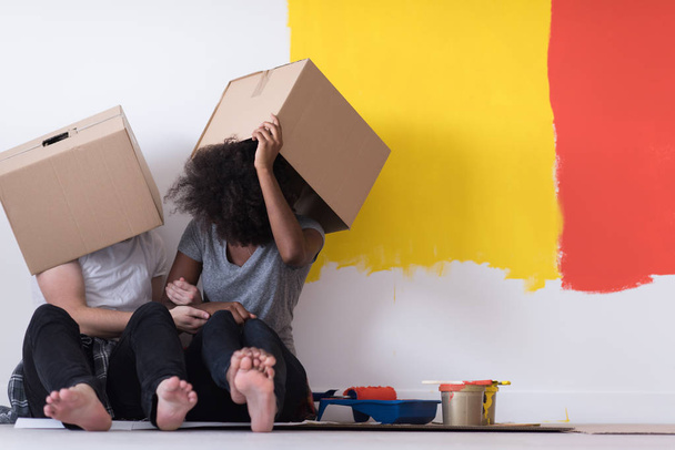 junges multiethnisches Paar spielt mit Pappkartons - Foto, Bild