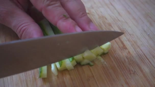 Affettare il cetriolo su una tavola di legno
. - Filmati, video