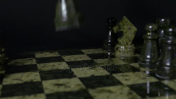 O elefante negro no xadrez derrota o cavalo branco. Detalhe da peça de xadrez sobre fundo preto. Jogo de xadrez. vista de perto. Foco seletivo
 - Filmagem, Vídeo