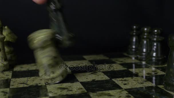 Μαύρη βασίλισσα στο σκάκι ήττες λευκό βράχο. Σκάκι η βασίλισσα κερδίζει νίκη πέρα από το παιχνίδι. Λεπτομέρεια της κομμάτι σκάκι σε μαύρο φόντο. Επιλεκτική foucs - Πλάνα, βίντεο