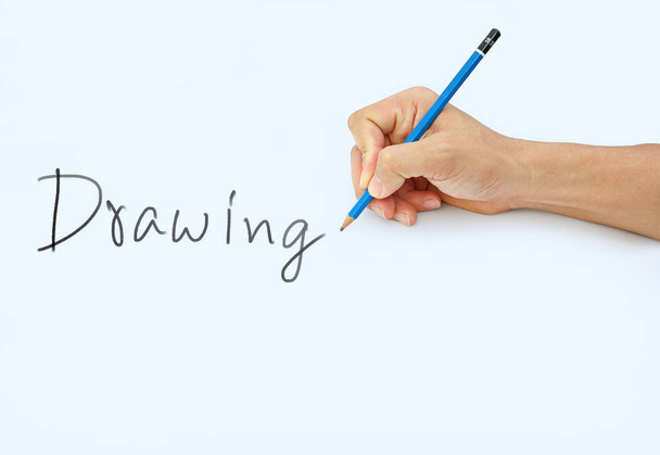 Hand holding a pencil on a white paper background, writing with pencil for word " Drawing " - Photo, Image