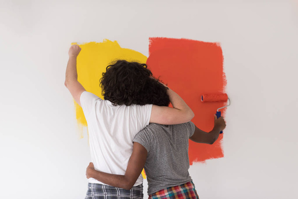 multiethnic couple painting interior wall - Фото, зображення