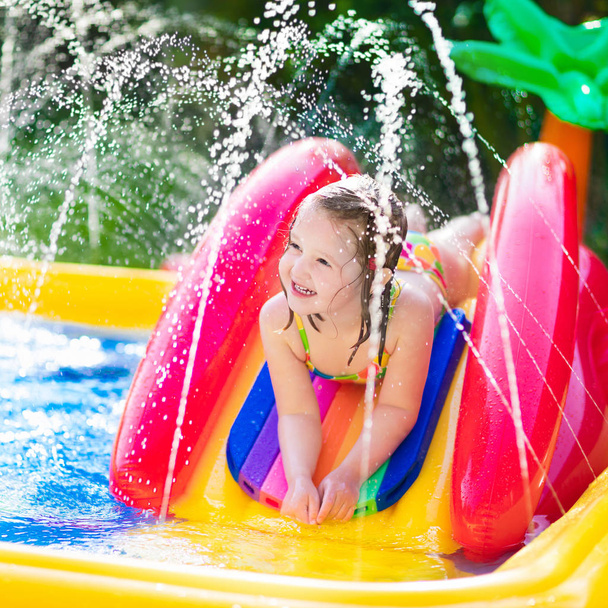 Little girl playing in inflatable garden swimming pool - Foto, Imagem