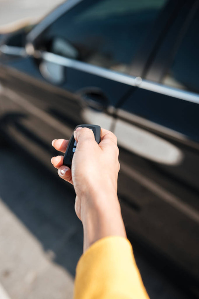 Woman hand holding keys and closing door of her car - Fotografie, Obrázek