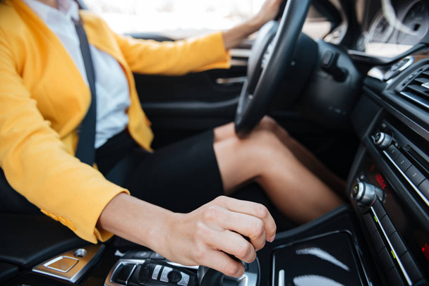 Woman shifting gears on gearbox and driving car - Φωτογραφία, εικόνα