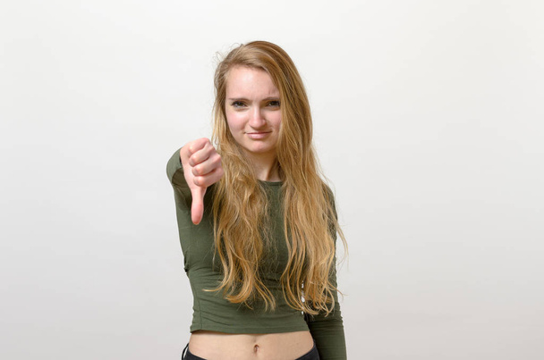 Lázadó negatív nő, amely a hüvelykujj le - Fotó, kép