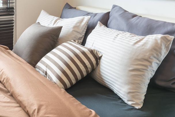set of pillows on modern bed in modern bedroom  - Valokuva, kuva