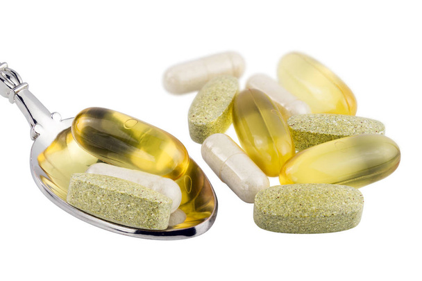 Vitamínový komplex, omega 3, glukosaminové tobolky, multivitaminové doplňky v lžíci izolované na bílém pozadí. - Fotografie, Obrázek